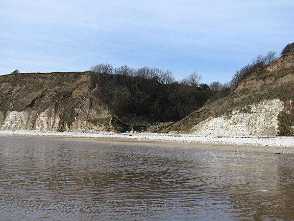 Fig. 1. The palaeo-valley at Danes’ Dyke, Flamborough Head, East Yorkshire, cut into Chalk bedrock. View looking NW. Chalk forms the lower third of the cliffs adjacent to the  palaeo-valley overlain by periglacial and glacigenic sediments. The modern valley is cut through this drift fill.  Cliff height is approximately 30m.